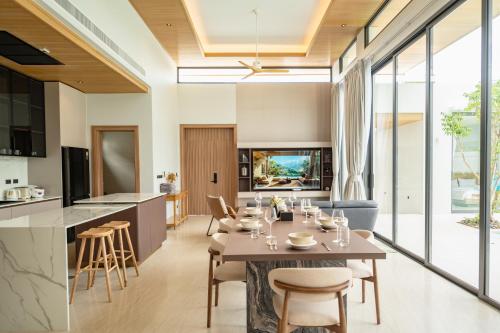 a kitchen and living room with a table and chairs at Mouana Residence Song Khun Chalong 5-bedroom Pool Villa 89-11 in Chalong 