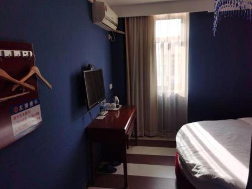 a bedroom with a bed and a desk and a window at Shell Hotel Shanghai Baoshan Meilanhu Luosheng Road in Shanghai