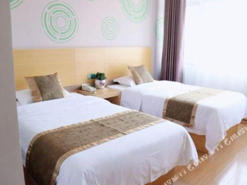 a hotel room with two beds and a window at GreenTree Inn Shanghai Fengxian District Xiaotang Metro Station in Shanghai