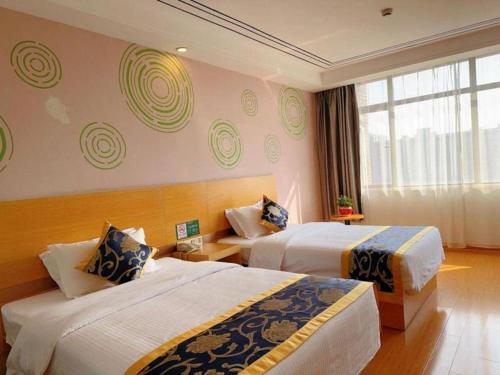 a hotel room with two beds and a window at GreenTree Inn Shanghai Fengxian District Xiaotang Metro Station in Shanghai