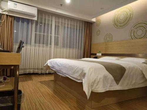 a bedroom with a large bed and a television at GreenTree Inn Beijing Shunyi Fengbo Metro Station in Beijing