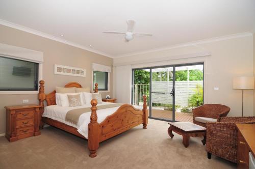 a bedroom with a bed and a sliding glass door at CeeSpray - Accommodation in Huskisson - Jervis Bay in Huskisson