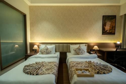 a hotel room with two beds with blankets on them at Hotel Mivaante in Ahmedabad