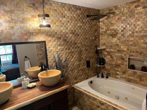 a bathroom with two sinks and a tub and a mirror at Priv Hidden retreat ATV trails spa fishing outdoor activities in Jefferson