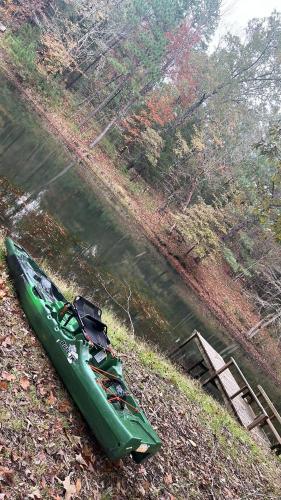 a green kayak sitting on the side of a river at Priv Hidden retreat ATV trails spa fishing outdoor activities in Jefferson
