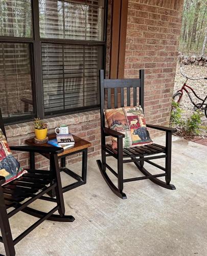 two rocking chairs and a table on a porch at Priv Hidden retreat ATV trails spa fishing outdoor activities in Jefferson