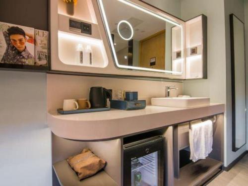 a bathroom with a sink and a mirror at Yitel Collection Shanghai Hongqiao Airport in Shanghai