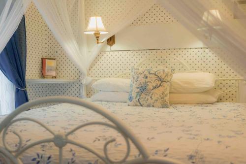 a bedroom with a bed with a canopy and pillows at Cabernet House, an Old World Inn in Napa