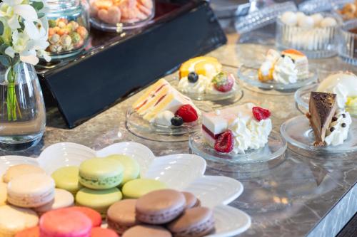 a table topped with cakes and desserts on plates at The Yokohama Bay Hotel Tokyu in Yokohama