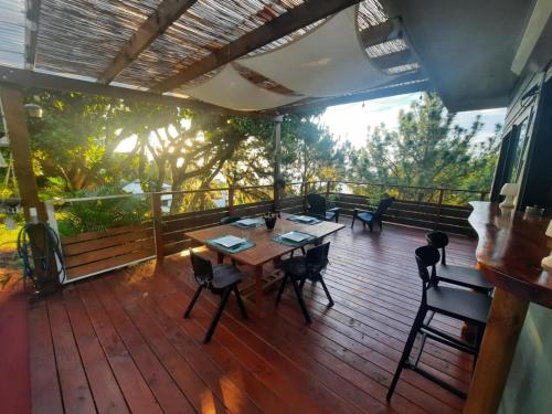 a wooden deck with a table and chairs on it at Fare TANGARA in Arue