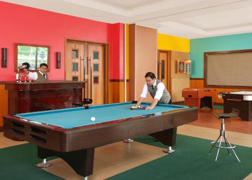 a man playing pool in a room with a pool table at Hotel Kimberly Tagaytay in Tagaytay