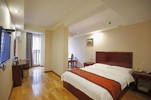 a bedroom with a large bed and a television at GreenTree Inn Chengdu North Railway Station Beichengtianjie Business Hotel in Chengdu