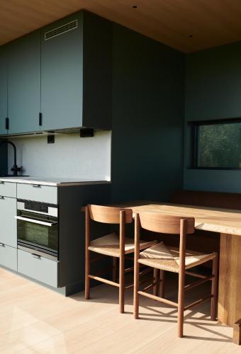 a kitchen with a wooden table and chairs at Grend Stavern in Larvik