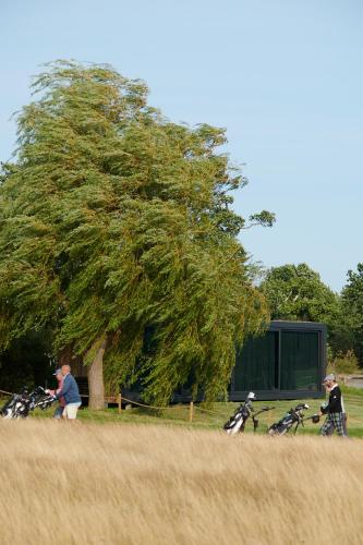 two people riding bikes in front of a tree at Grend Stavern in Larvik