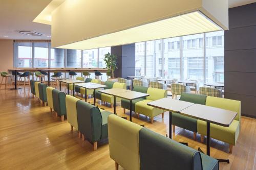 a dining room with tables and chairs and windows at Kobe Motomachi Tokyu REI Hotel in Kobe