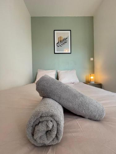 - un lit avec un tas de serviettes dans l'établissement Charmant T2 avec cour extérieure, à Cholet