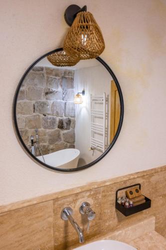 a mirror on a wall above a bathroom sink at Cappadocia Naif Hotel - Adults Only in Goreme