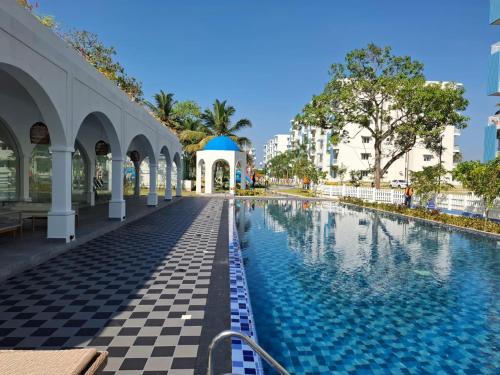 a swimming pool at a resort with a checkered floor at Santorini Apartments 1D F5 U8 in Negombo