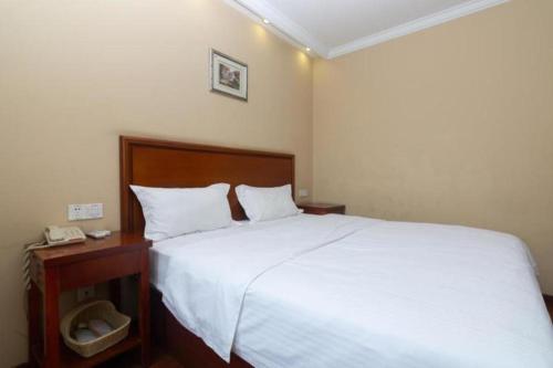 a bedroom with a large white bed and a telephone at GreenTree Inn Shanghai Hongqiao Airport Huqingping Highway Shell Hotel in Shanghai