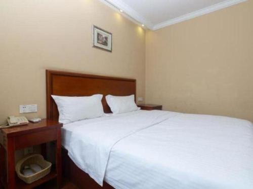 a bedroom with a large white bed and a telephone at GreenTree Inn Shanghai Hongqiao Airport Huqingping Highway Shell Hotel in Shanghai