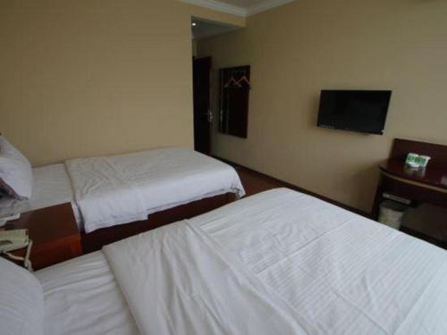 a hotel room with two beds and a television at GreenTree Inn Shanghai Hongqiao Airport Huqingping Highway Shell Hotel in Shanghai