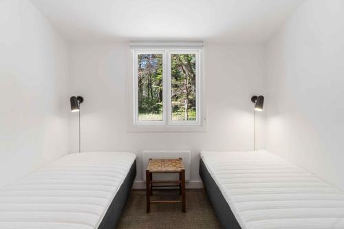 zwei Betten in einem Zimmer mit Fenster in der Unterkunft Renovated Cottage Near Forest And Beach in Rørvig