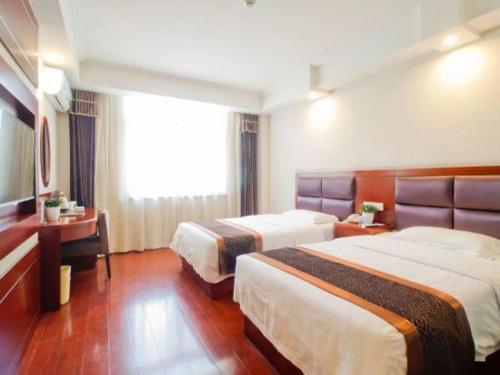 a hotel room with two beds and a window at GreenTree Inn HeFei LongChuan Road South Hefei Railway Station Business Hotel in Hefei