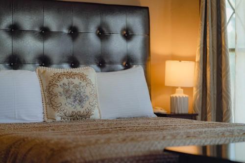 a bed with a black headboard and white pillows at Cabernet House, an Old World Inn in Napa