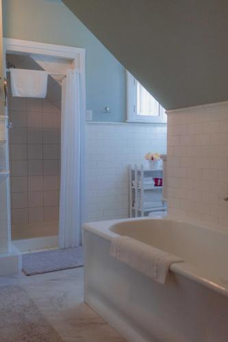 a white bathroom with a tub and a shower at Cabernet House, an Old World Inn in Napa