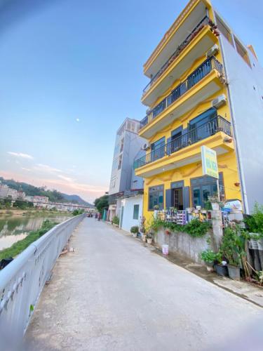 un edificio giallo sul lato di un ponte di Gia Linh Homestay a Cao Bằng
