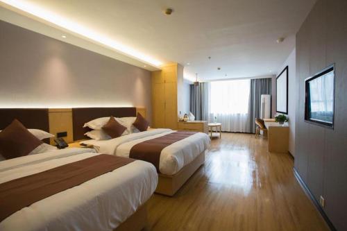 a hotel room with two beds and a living room at GYA Hotel Shanghai Songjiang Wanda Plaza in Shanghai