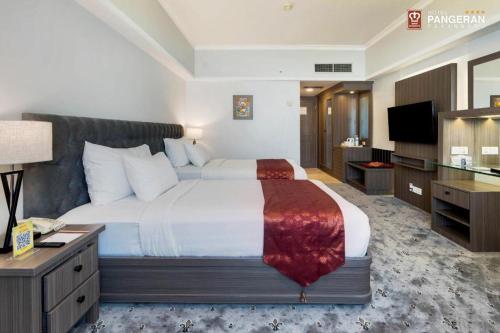 a hotel room with a large bed and a television at Hotel Pangeran in Pekanbaru