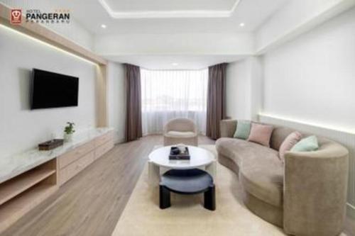 a living room with a couch and a table at Hotel Pangeran in Pekanbaru