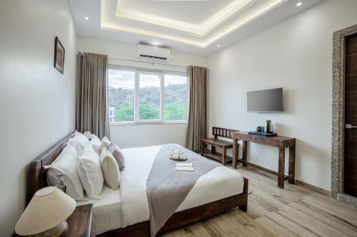 a hotel room with a bed and a window at Alaya Stays Kodiyat 4-BHK Pet-Friendly Villa With Views of Sajjangarh Palace in Nāi