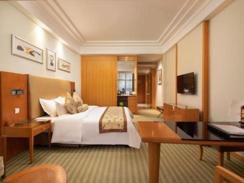 a hotel room with a bed and a desk at Changshu Jinling Tianming Grand Hotel in Suzhou
