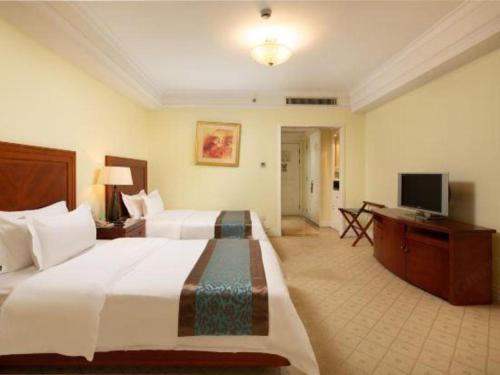 a large hotel room with two beds and a television at Changshu Jinling Tianming Grand Hotel in Suzhou