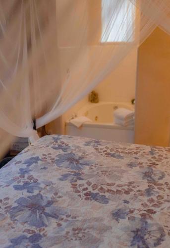 a bedroom with a bed with a curtain and a tub at Cabernet House, an Old World Inn in Napa