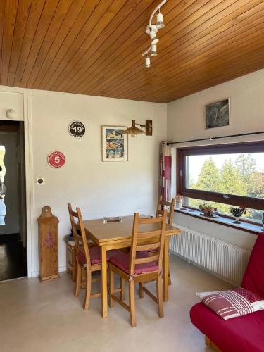 une salle à manger avec une table et des chaises en bois dans l'établissement Appartement cosy à Chamrousse avec vue sur montagne + 34m²., à Chamrousse