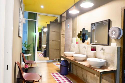 a bathroom with two sinks on a counter with chairs at Sleep cafe @ Hidee in Bangkok
