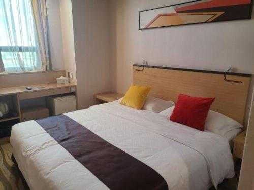 a bedroom with a large bed with four pillows at Cozy Hotel Xiamen in Xiamen