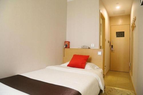 a bedroom with a bed with a red pillow on it at Cozy Hotel Xiamen in Xiamen