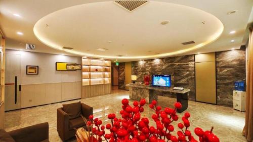 a lobby with red flowers in the middle of a room at Cozy Hotel Xiamen in Xiamen