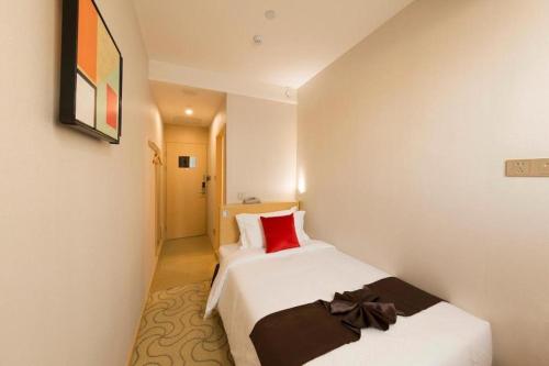 a hotel room with two beds with red pillows at Cozy Hotel Xiamen in Xiamen