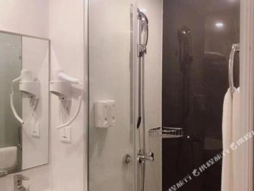 a shower with a glass door in a bathroom at Cozy Hotel Xiamen in Xiamen