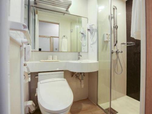 a bathroom with a toilet and a sink and a shower at Cozy Hotel Xiamen in Xiamen