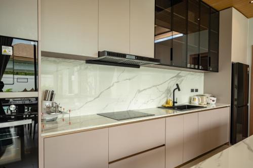 a kitchen with white marble countertops and stainless steel appliances at Mouana Residence Song Khun Chalong 5-bedroom Pool Villa 89-11 in Chalong 