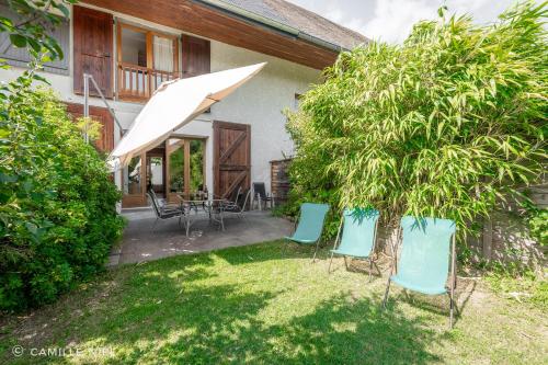 un groupe de chaises et un parasol dans une cour dans l'établissement la Tarte Qui Flette, à Saint-Sulpice