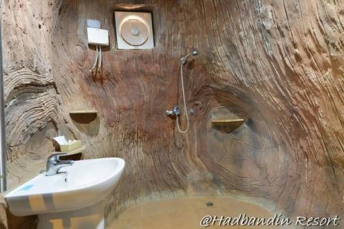 ein Badezimmer mit Waschbecken und Dusche in einer Holzwand in der Unterkunft Had Ban Din Resort in Ban Nong Pru