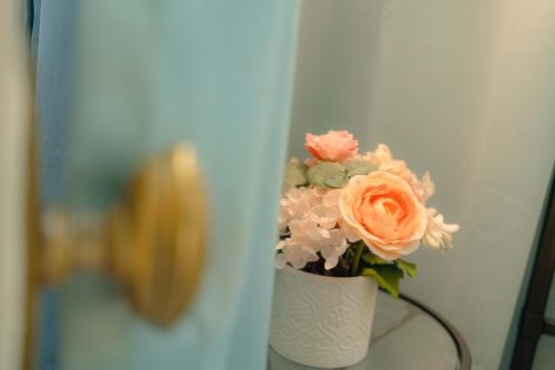 a white vase filled with flowers on a table at Cabernet House, an Old World Inn in Napa