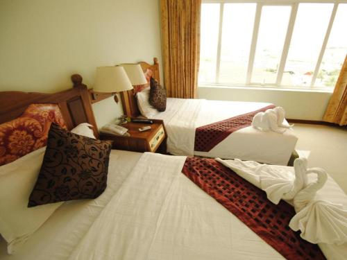 a hotel room with two beds and a window at Midland Hotel in Phnom Penh